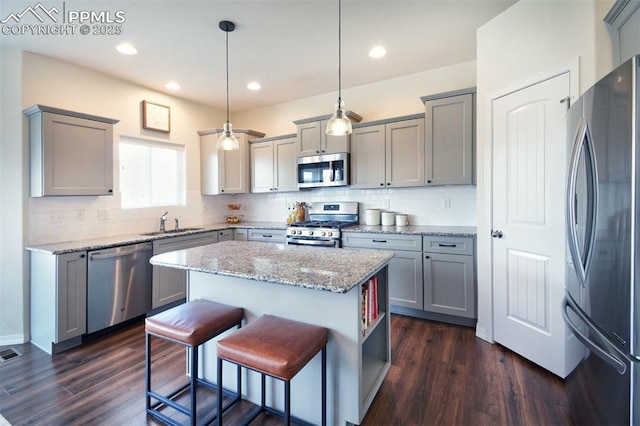 kitchen featuring dark wood-style flooring, gray cabinets, appliances with stainless steel finishes, and a sink