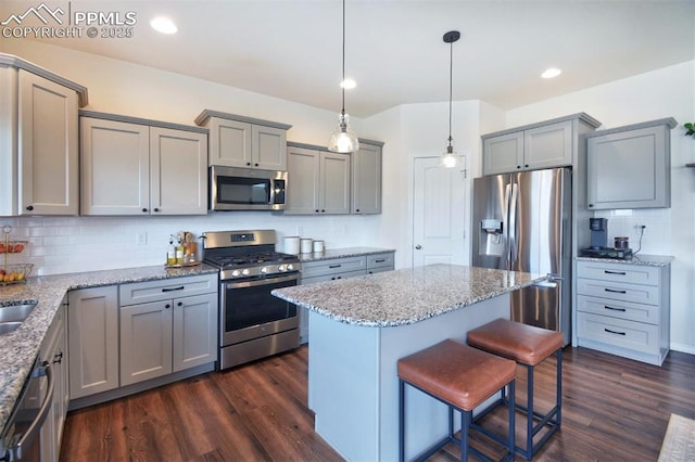 kitchen with appliances with stainless steel finishes, dark wood finished floors, and gray cabinetry