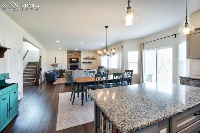 kitchen featuring recessed lighting, dark wood-type flooring, a fireplace, and hanging light fixtures