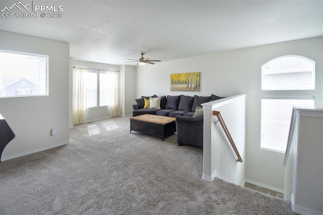 carpeted living room featuring baseboards and ceiling fan