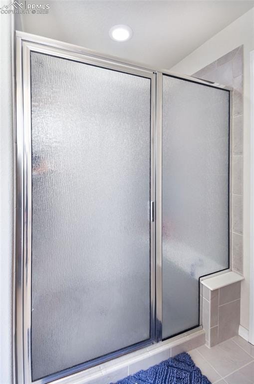 bathroom with tile patterned flooring and a shower stall