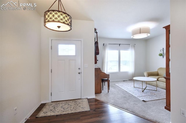 foyer featuring baseboards and dark wood finished floors