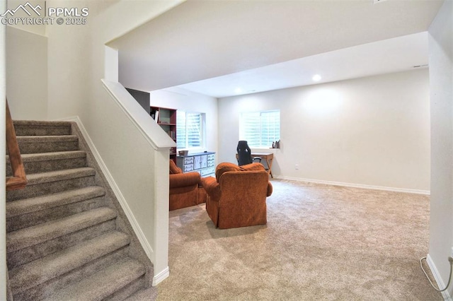 sitting room featuring recessed lighting, light colored carpet, stairs, and baseboards