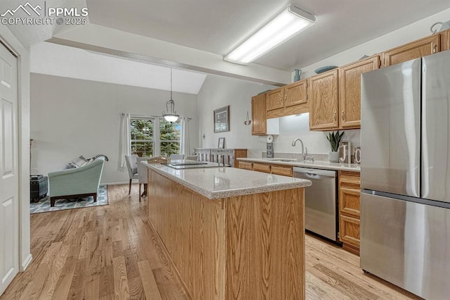 kitchen with a center island, lofted ceiling, light wood-style flooring, appliances with stainless steel finishes, and a sink