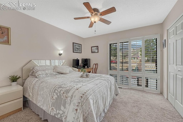 bedroom with carpet floors, access to exterior, a ceiling fan, and a textured ceiling