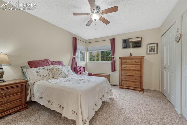 carpeted bedroom with baseboards, a closet, a ceiling fan, and a textured ceiling