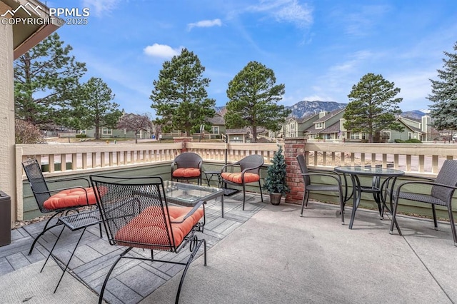 view of patio with a residential view, a mountain view, and outdoor dining space