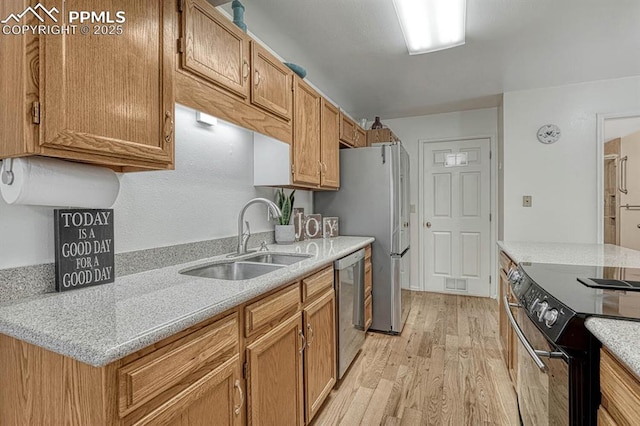 kitchen with light countertops, light wood-style floors, a sink, dishwasher, and black / electric stove