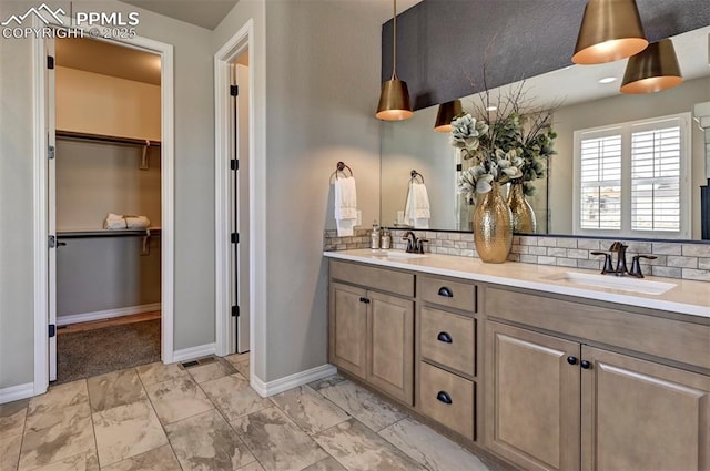 bathroom with marble finish floor, a sink, and double vanity