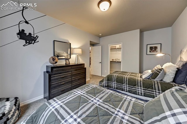 carpeted bedroom with a closet, a spacious closet, and baseboards