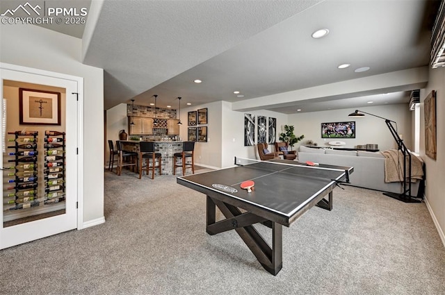 game room with baseboards, a textured ceiling, carpet flooring, a bar, and recessed lighting