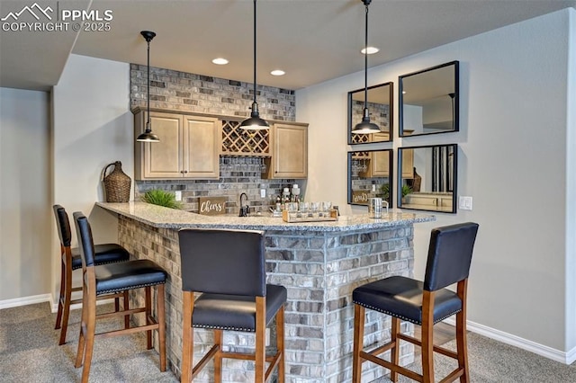 bar with wet bar, baseboards, dark carpet, and decorative backsplash