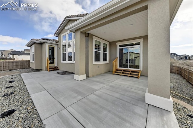 back of house featuring entry steps, a patio area, a fenced backyard, and stucco siding