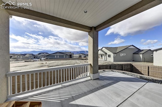 deck featuring a residential view, fence, and a mountain view