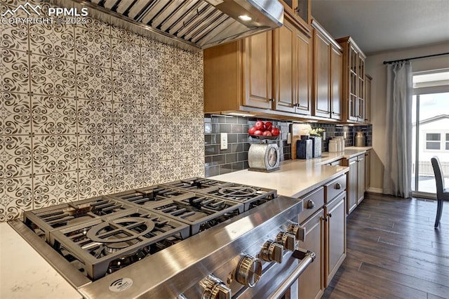 kitchen featuring custom exhaust hood, light countertops, backsplash, dark wood-type flooring, and glass insert cabinets