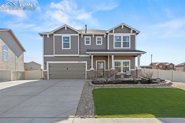 craftsman inspired home featuring a front yard, fence, covered porch, and driveway