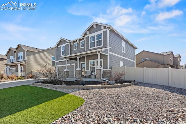 craftsman-style house with fence, a residential view, a porch, a front yard, and stone siding