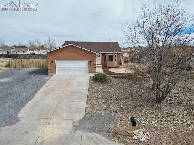 ranch-style home with concrete driveway, fence, an attached garage, and stucco siding