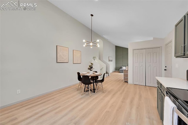 dining space featuring baseboards, light wood-style flooring, and an inviting chandelier