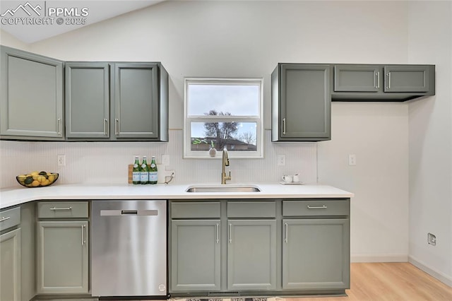 kitchen featuring gray cabinets, dishwasher, and a sink