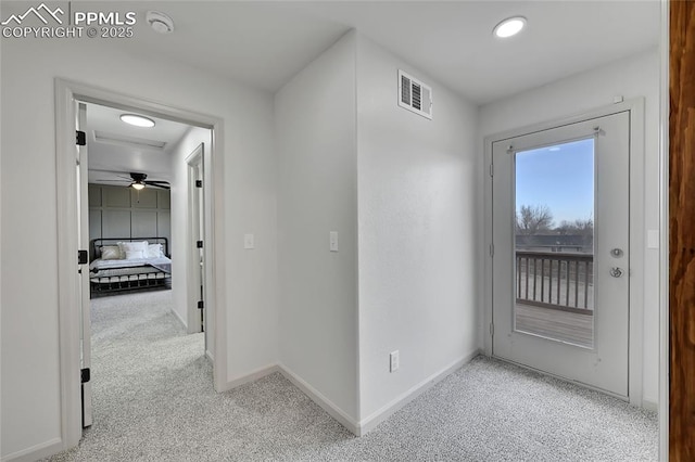 hall featuring carpet floors, visible vents, and baseboards