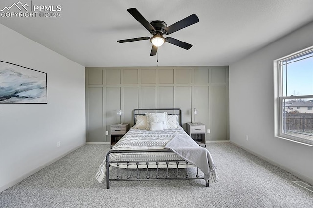 bedroom featuring baseboards, visible vents, a ceiling fan, and light colored carpet