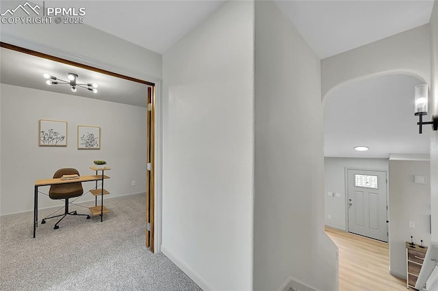 hallway with arched walkways and baseboards