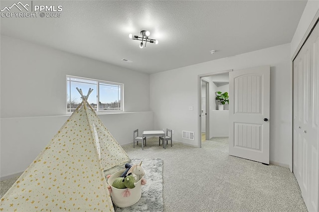 game room with carpet floors, visible vents, a textured ceiling, and baseboards