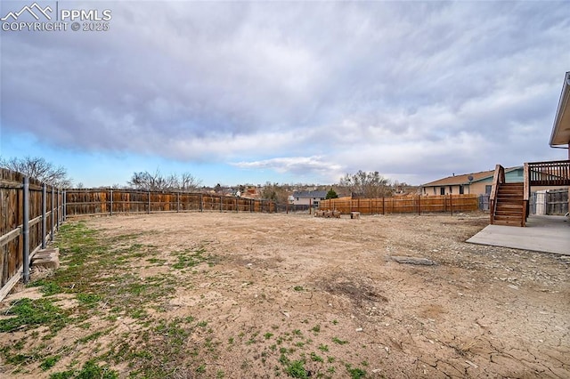 view of yard featuring a fenced backyard and stairway