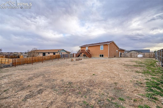 rear view of house featuring a fenced backyard