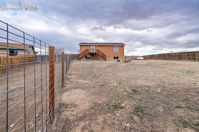 back of property with stairs and a fenced backyard