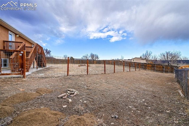 view of yard with a fenced backyard and stairs