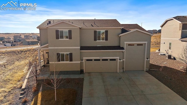 traditional home featuring an attached garage, cooling unit, and concrete driveway