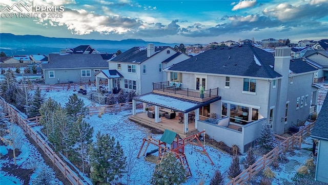 exterior space featuring a deck with mountain view, a residential view, and stucco siding