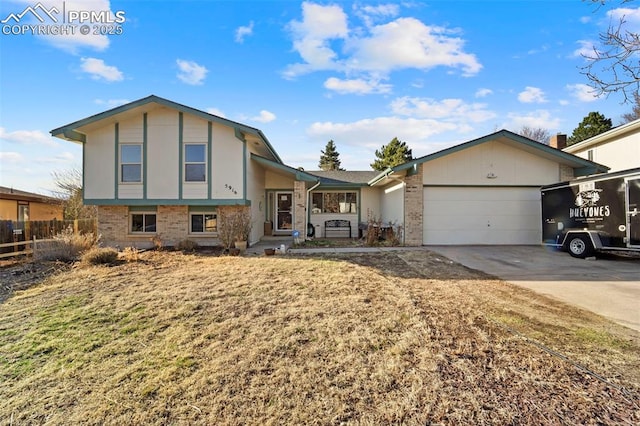 tri-level home featuring driveway, brick siding, an attached garage, and fence