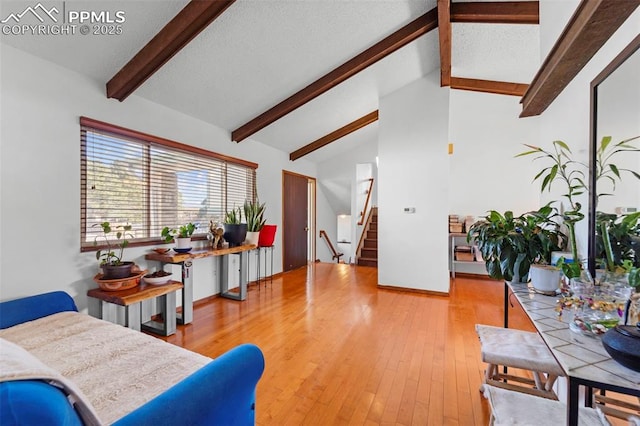 living room with vaulted ceiling with beams, stairway, a textured ceiling, and wood finished floors