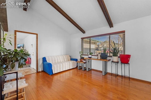 living area with high vaulted ceiling, beam ceiling, baseboards, and hardwood / wood-style floors