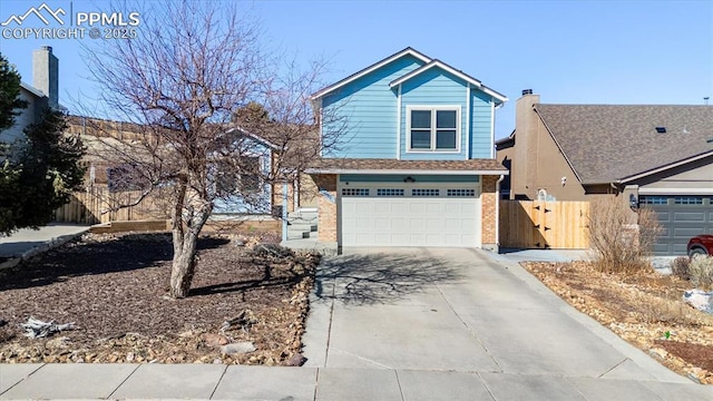 view of front of home with a garage, driveway, and fence