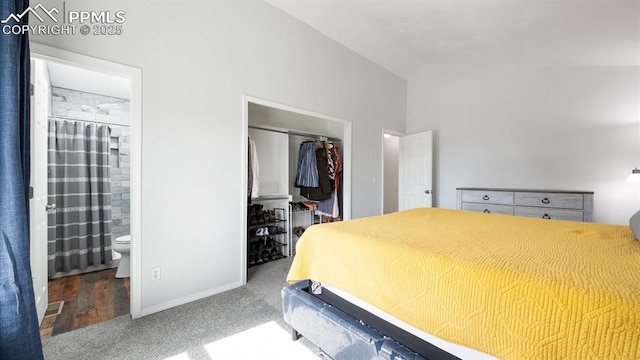 bedroom with connected bathroom, carpet, a spacious closet, vaulted ceiling, and a closet