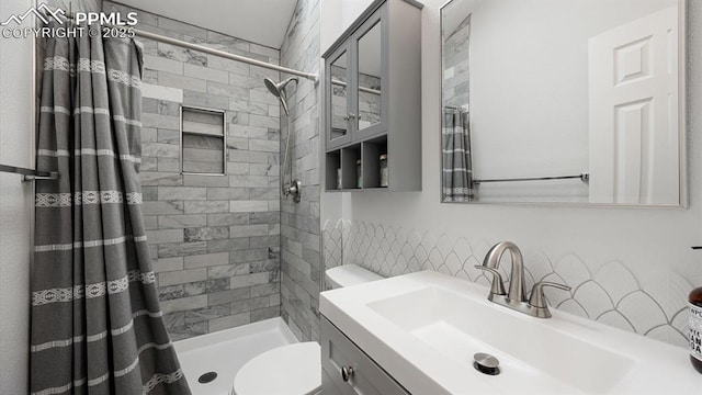 bathroom featuring a stall shower, vanity, and toilet