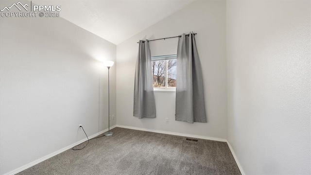 empty room with lofted ceiling, carpet floors, visible vents, and baseboards