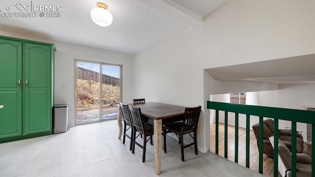 dining area featuring lofted ceiling with beams