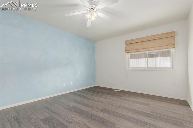 spare room with ceiling fan, wood finished floors, and baseboards