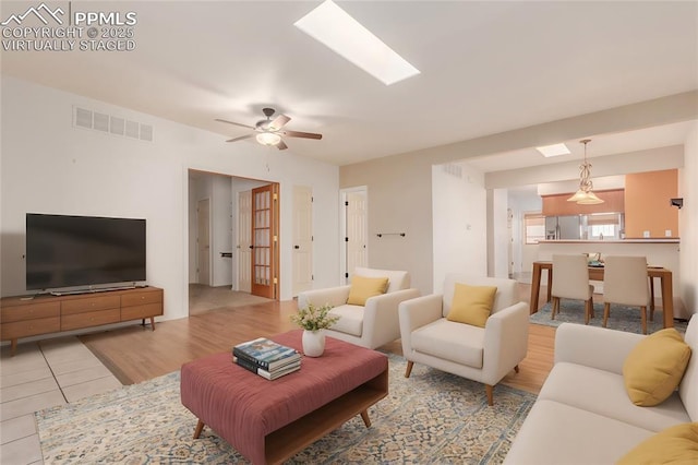 living room featuring ceiling fan, light wood-style flooring, and visible vents