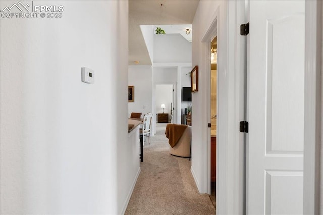 hall featuring light carpet and baseboards