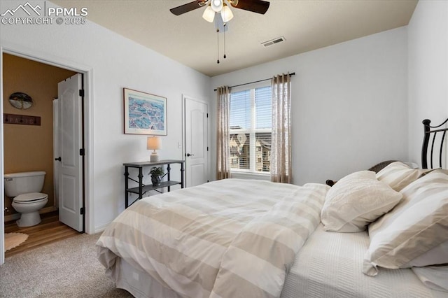 bedroom featuring carpet, visible vents, ceiling fan, and ensuite bathroom