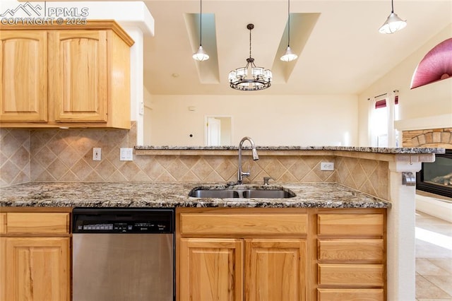 kitchen with backsplash, light brown cabinetry, stone counters, stainless steel dishwasher, and a sink