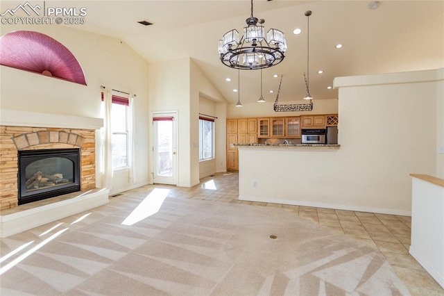 kitchen featuring light tile patterned floors, a stone fireplace, light colored carpet, and oven