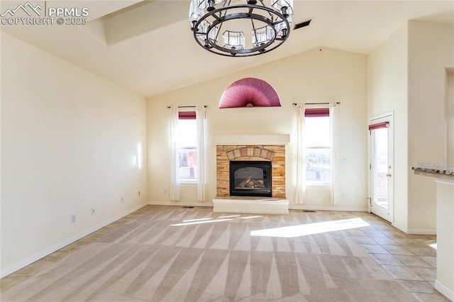 unfurnished living room featuring a wealth of natural light, carpet flooring, a stone fireplace, and lofted ceiling