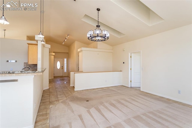 kitchen with backsplash, light colored carpet, pendant lighting, lofted ceiling, and a notable chandelier